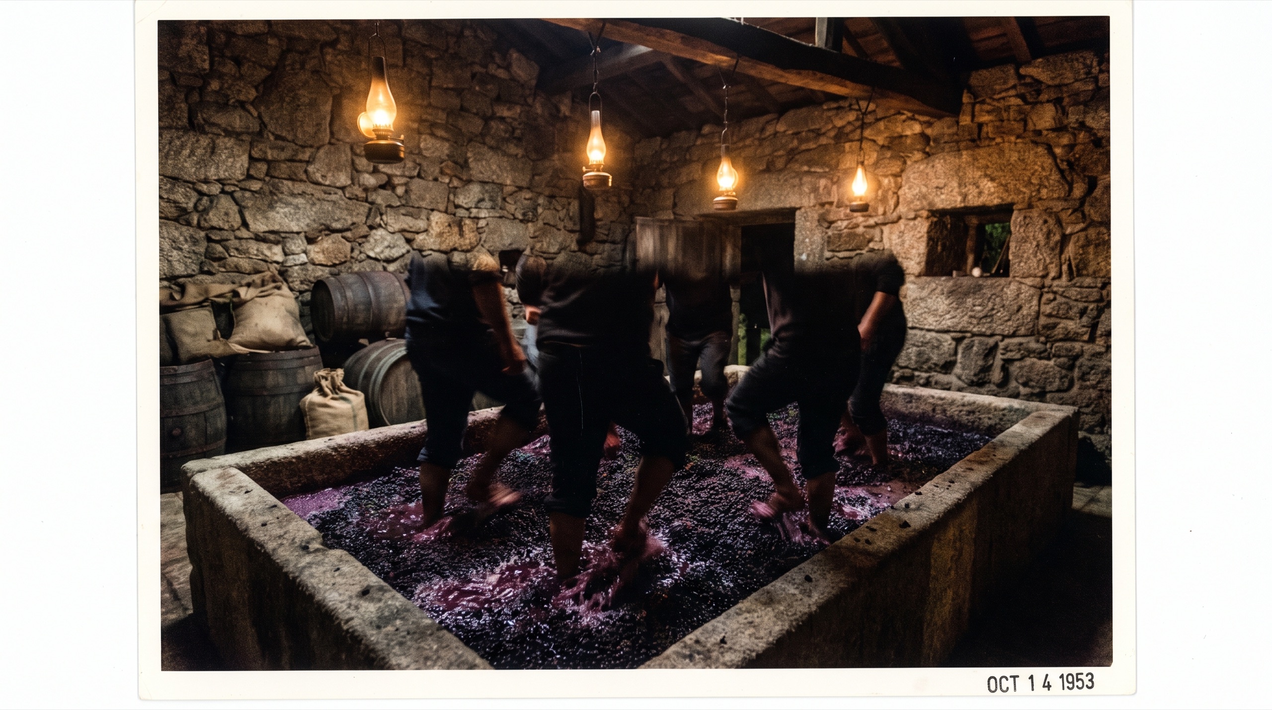 Lagar de granito à noite, pernas de lagareiros em movimento no mosto, lâmpadas quentes
